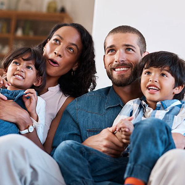 A Family of Four Relaxes on a Couch, Sharing Smiles and Joy in Atlanta, GA