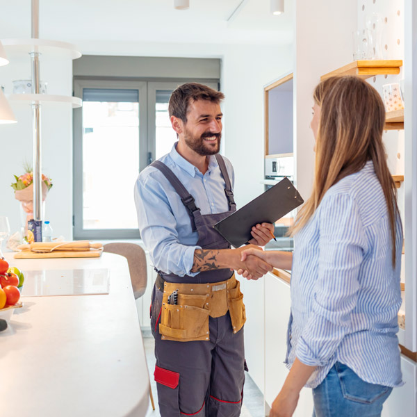 A Technician and a Woman Shakes Hands in the Kitchen after a Plumbing Service in Atlanta, GA