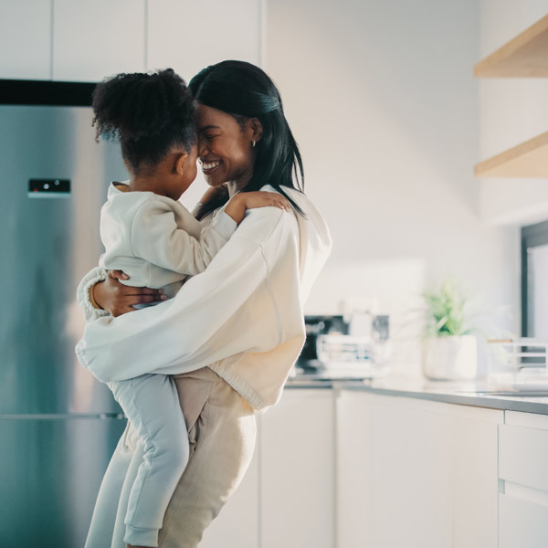 mom and daughter hugging in kitchen