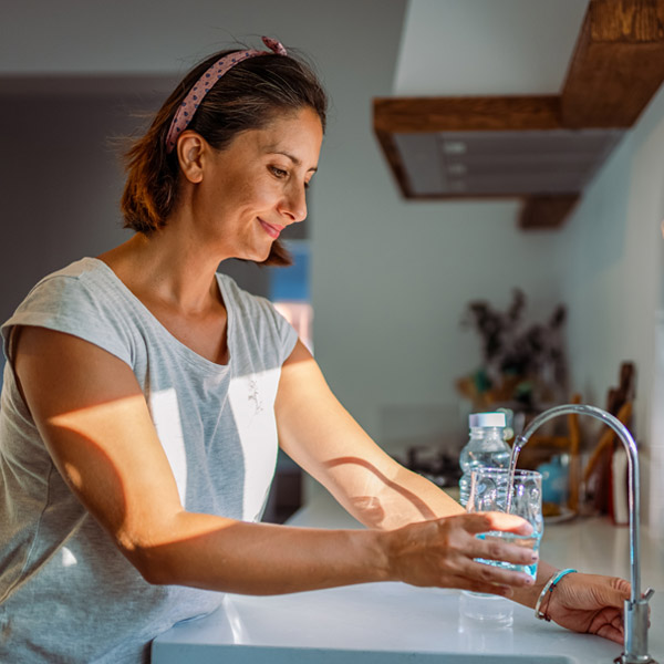 A woman holding glass of water showing the water purification services available in Atlanta, GA.