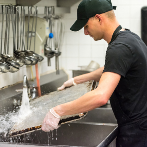 A Man Wasing Dishes in Kitchen Highlighting Commercial Plumbing Service in Atlanta, GA
