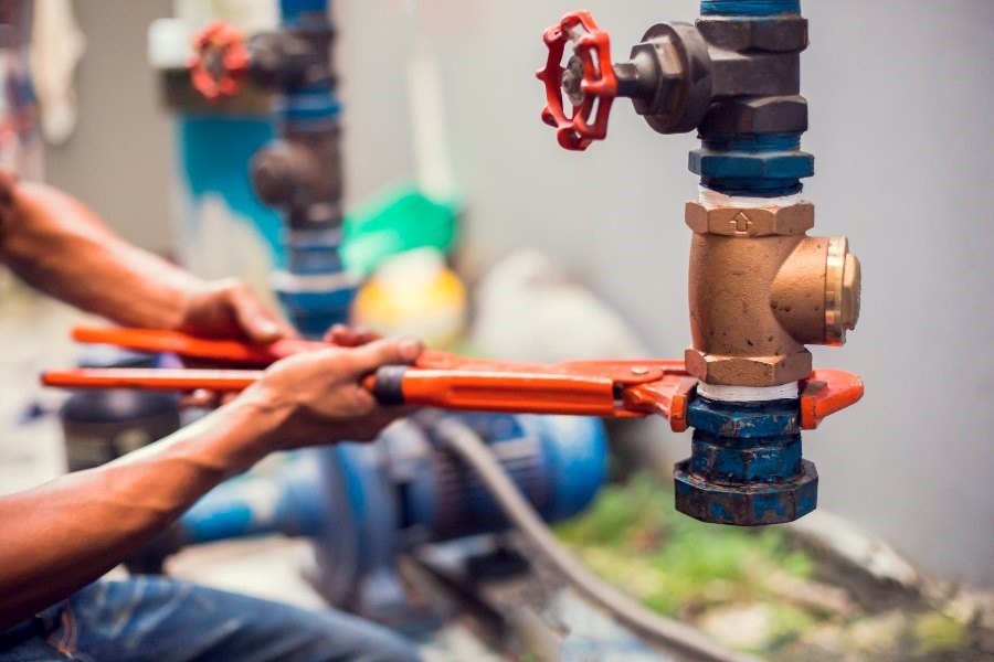  A Man is Repairing a Water Valve, Showcasing Plumbing Services in Atlanta, GA