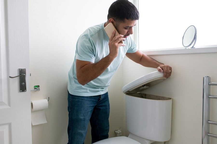 A person is contacting a plumbing company for toilet tank repair services in Mableton & Cobb County