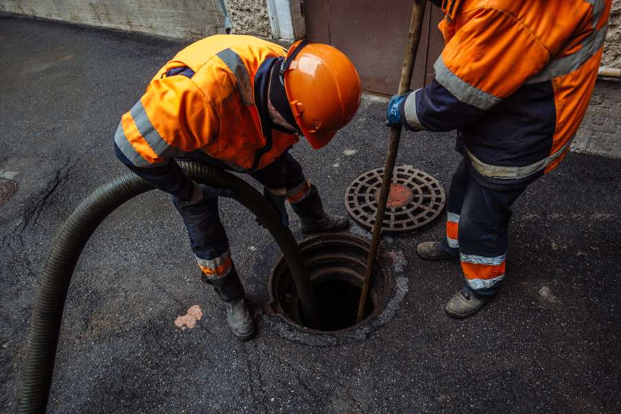 Two professionals cleaning clogging drains with the machine in Atlanta, GA