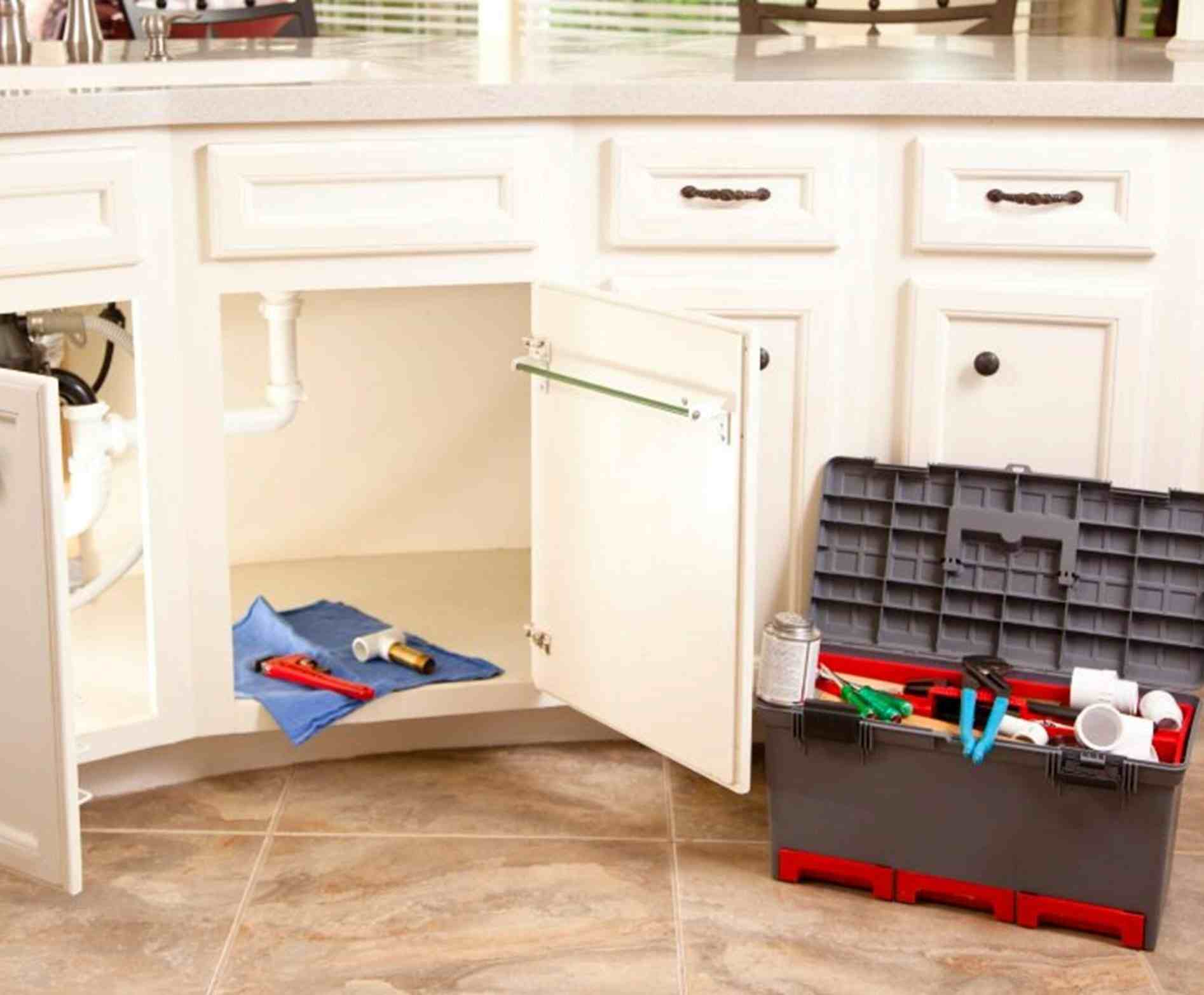 A kitchen sink accompanied by tools and a cabinet, situated in Atlanta, GA