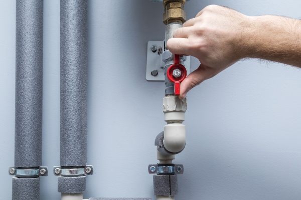 Plumber turning off hot water pipe