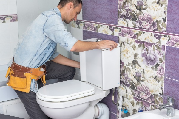 Plumber repairing toilet