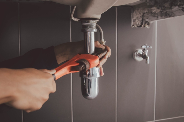 Plumber working on sink in a home's bathroom