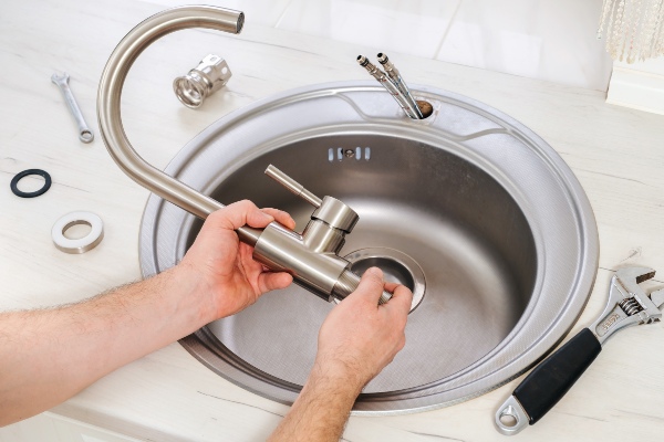 Plumber assembling and installing new faucet